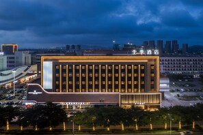 A modern hotel with a prominent entrance and a parking lot in front. - Ji Hotel Zhuhai Gaolangang Shopping Center (Zhuhai)