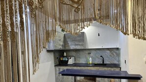 Een kleine keuken met een marmeren aanrecht, een inbouwoven en een klein spoelbakje.