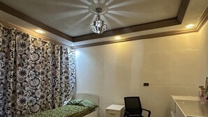 Een slaapkamer met een bed, een bureau en een stoel.