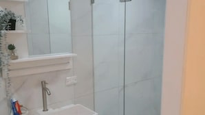 A bathroom with a white sink, a mirror, and a shower area. - Private guest suite @ Sorrento (Bundall)