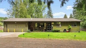 A single-story house with a garage, a front porch, and a well-maintained lawn. - Cedar Trees Retreat (Sandpoint)