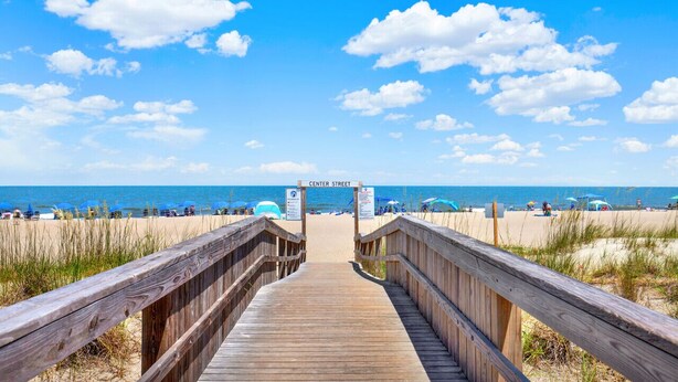 A wooden boardwalk leading to a beach with a sign reading "Center Street". - Beachfront Condo w Ocean Views and Pool (Tybee Island)