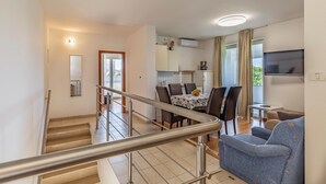 Un appartement moderne comprenant un escalier, un coin repas, un salon avec un canapé et une cuisine.