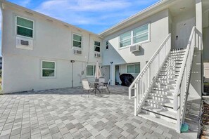 A two-story building with a patio area, outdoor seating, and a staircase. - Pompano Beach 1BR | Near the Beach (Pompano Beach)