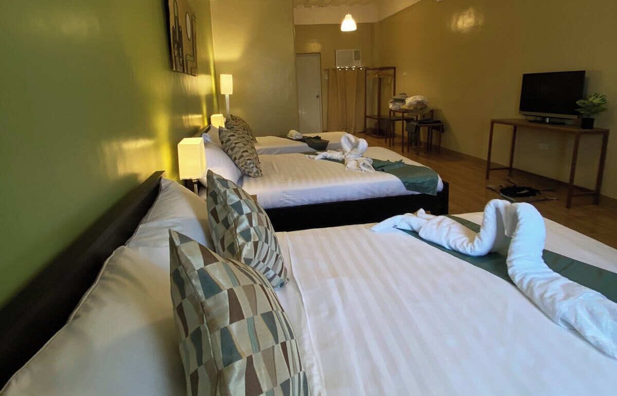 Une chambre d’hôtel avec deux lits, une télévision, un bureau et une chaise.