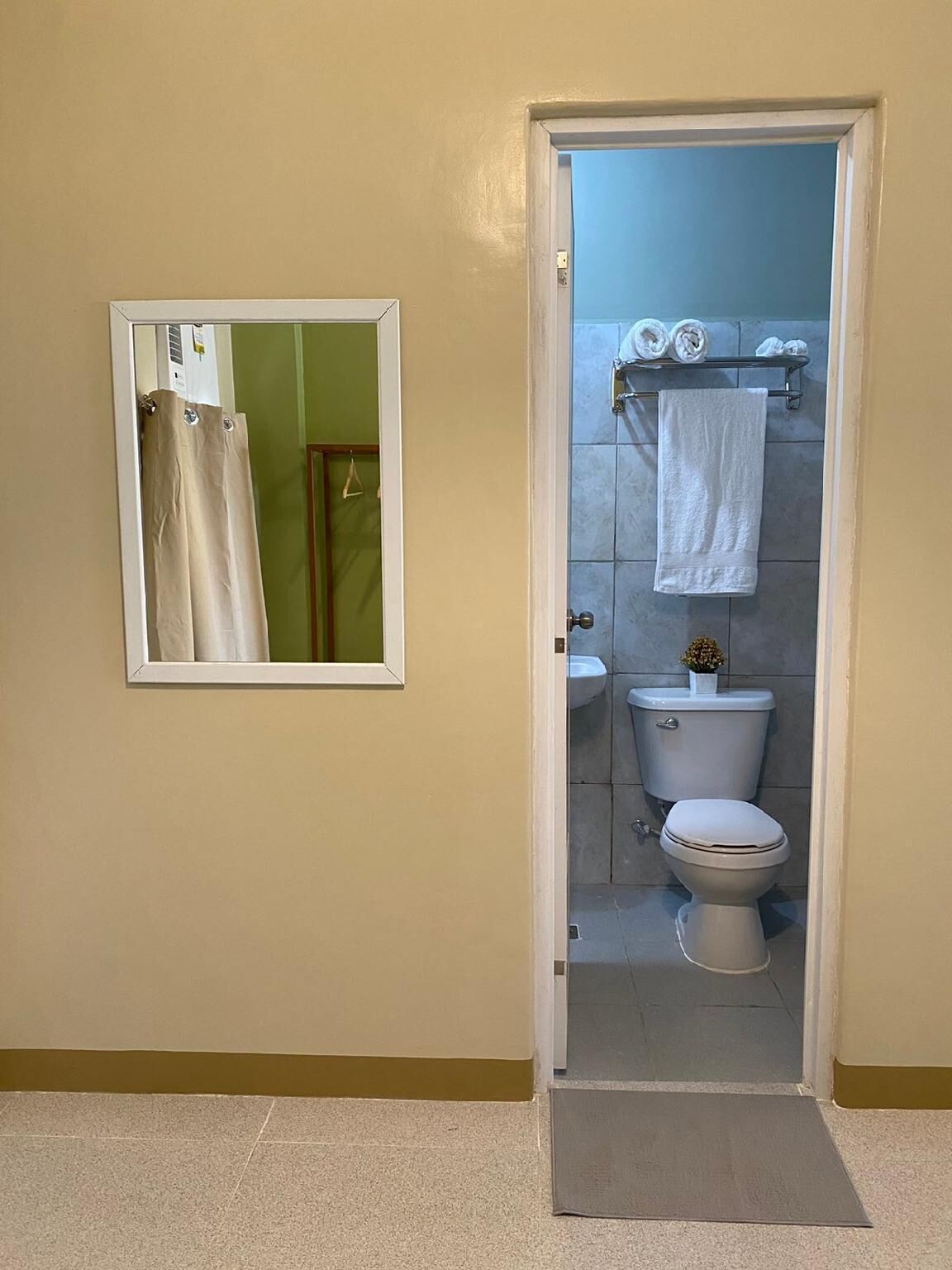 Un baño con inodoro, lavabo y perchero para toallas.