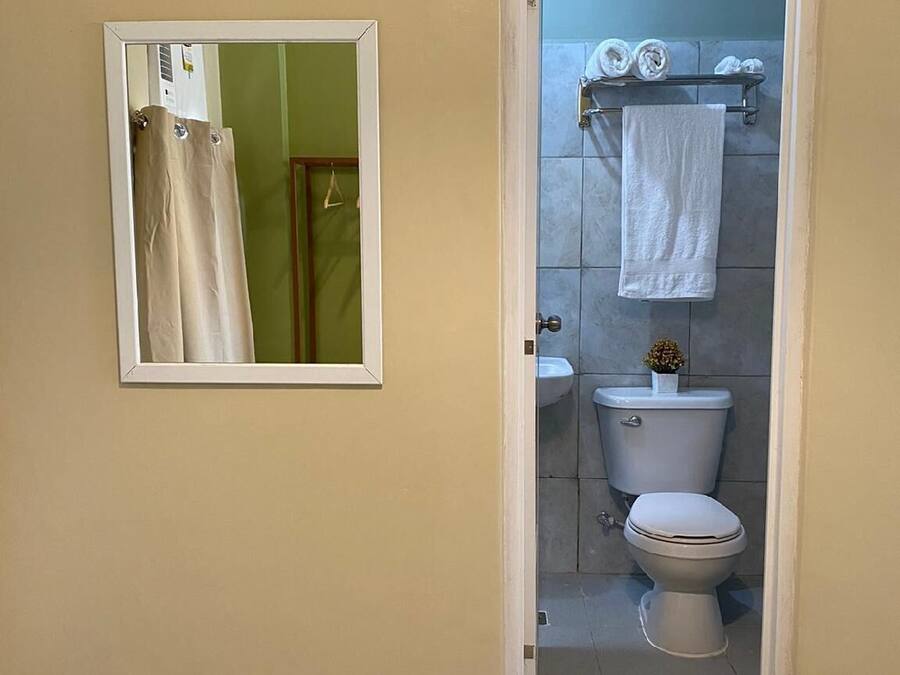 Un baño con inodoro, lavabo y perchero para toallas.