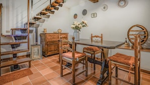 A dining area with a wooden table, chairs, and a staircase.