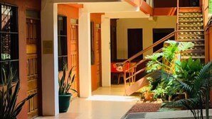 A two-story building with a covered outdoor area. - Hotel Cabinas Jacomar (Jacó)