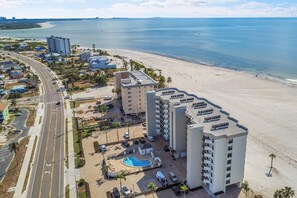 An aerial view of a coastal hotel with multiple buildings, a swimming pool, and a beach.