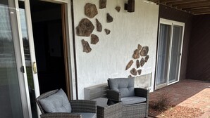 A patio area with wicker furniture and a stone wall. - Every Room with a Beautiful View of The Wisconsin River * (Tomahawk)