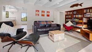 A modern living room with leather sofas, a wooden coffee table, and a bookshelf filled with books. - Brooks by the bay  - Blairgowrie (Blairgowrie)