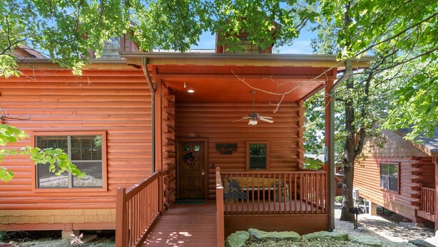 A log cabin with a porch, a front door, and a small front yard. - 2BD + Loft, Walk-In Cabin- Discounts on Golf & Tickets! (Branson)