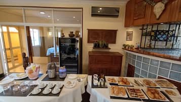 A dining area with a buffet setup, a refrigerator, and a bar area with a decorative skull.