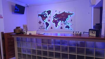 A reception desk with a world map, a television, and a sign that reads 'TIPS ARE APPRECIATED Thank you'.