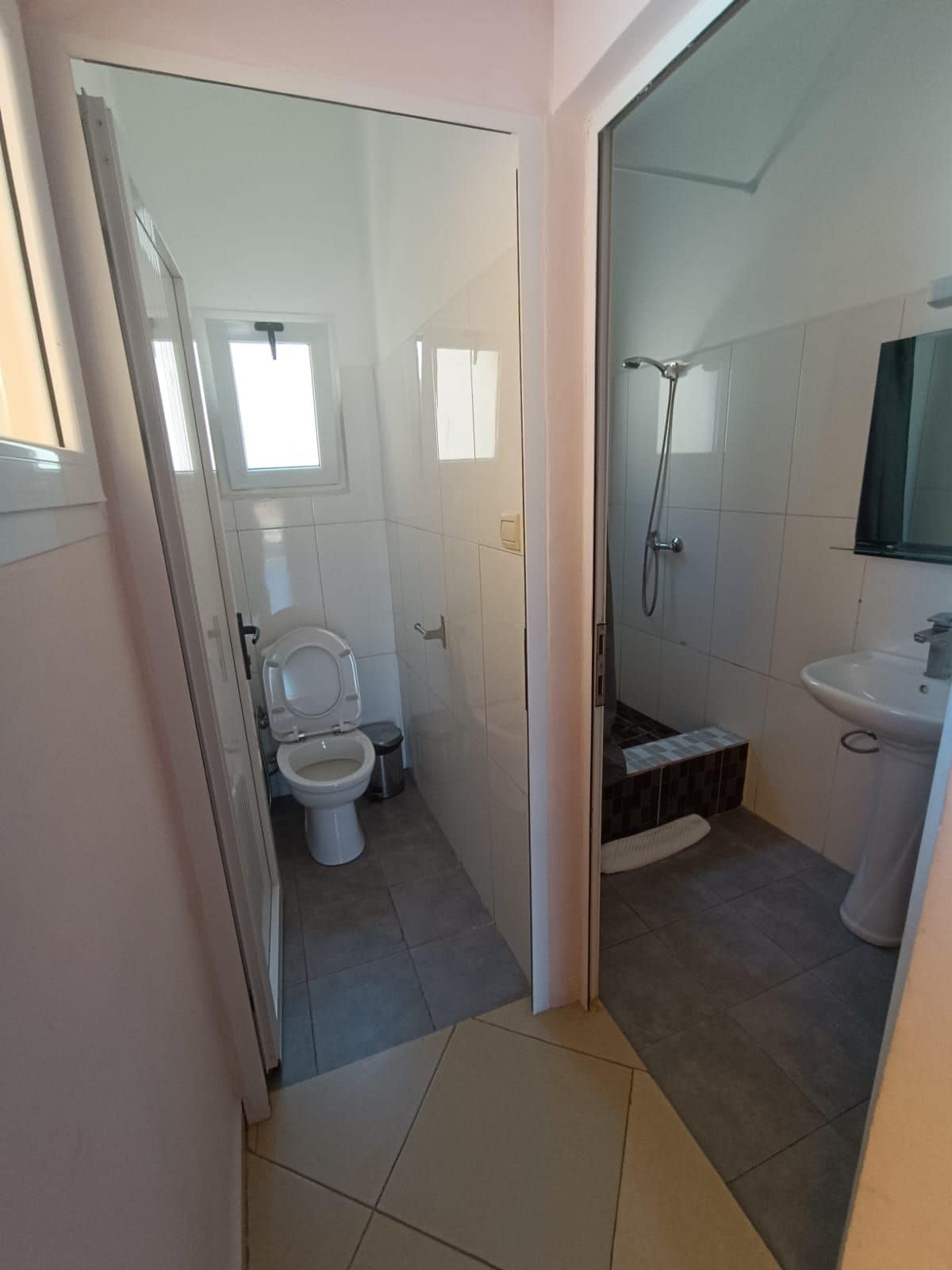 Un baño con inodoro, ducha y lavabo.