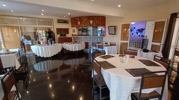A dining area with multiple tables, chairs, and a polished floor.