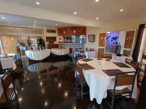 A dining area with multiple tables, chairs, and a polished floor. - Hôtel Les 12 Collines, Ivato Ambohijanahary (Antananarivo)