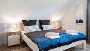 A bedroom with a bed, two bedside tables, a nightstand, a mirror, and a window. - Apartment 'Ferienwohnung Lisa' with Private Terrace, Private Garden and Wi-Fi (Behrensdorf)
