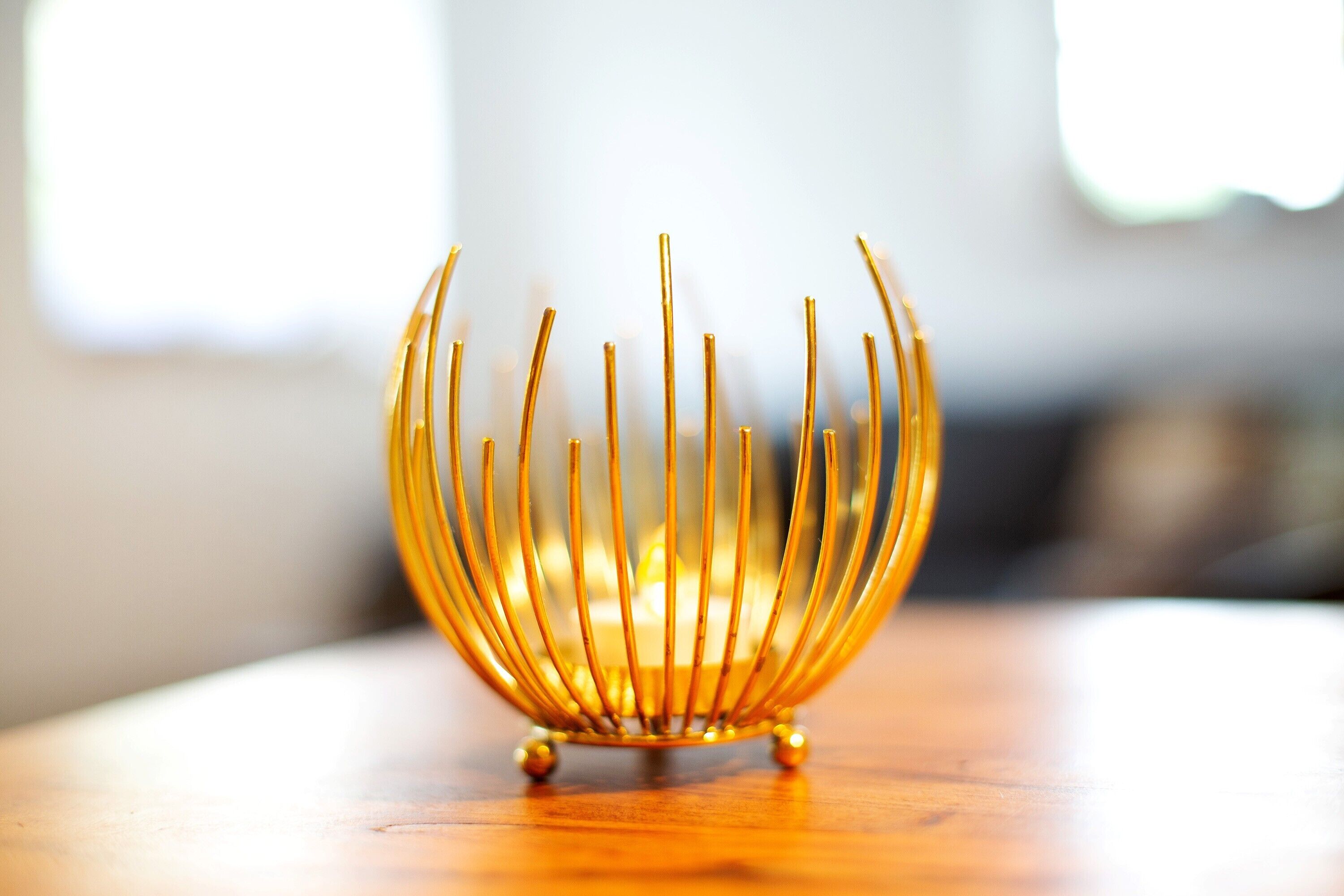 Een gouden decoratief object op een houten ondergrond.