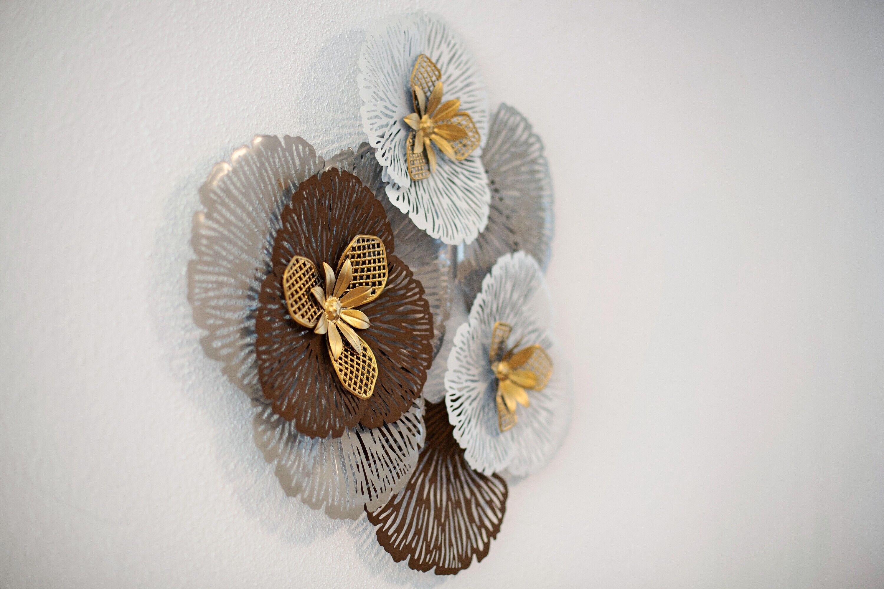 Eine Wand mit dekorativen Metallblumen.