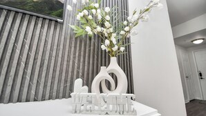 Un comptoir d’accueil avec une pancarte indiquant « BIENVENUE » et un vase rempli de fleurs blanches.