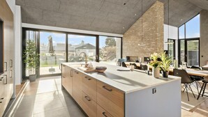 A modern kitchen with a large island, built-in appliances, and large windows offering views of the surrounding area. - 4 bedroom pet friendly home in Blokhus (Blokhus)