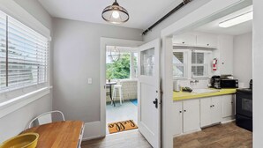A modern kitchen with white cabinets, a yellow countertop, and a black stove. - #StayinMyDistrict Historic Heritage Walk to Bay (Coos Bay)