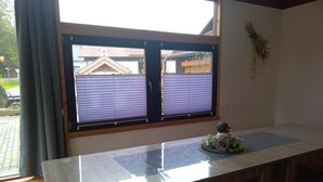 A room with a large window, a wooden table, and a decorative item on the table.