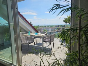 A balcony with a table set for two, overlooking a cityscape. - Sehr Attraktive Luxuriöse Wohnung mit Herrlichem Alpenblick! (Markdorf)