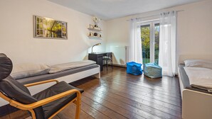 Una habitación con cama, escritorio, silla y ventana con cortinas.