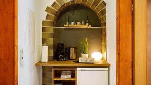 A kitchen with a brick arch, a coffee maker, a kettle, a potted plant, and a sign that reads 'TEATIME'. - Seelina Apartment in Perach – Quiet, Cozy & Close to Nature (Perach)
