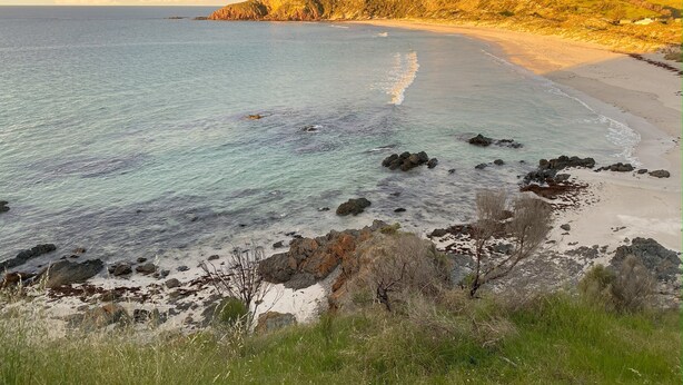 A coastal landscape with a sandy beach, rocky outcrops, and a hill with vegetation. - Gum Valley Quarters: perfect for large groups and families (Western River)