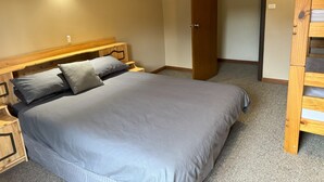 A bedroom with a bed, wooden headboard, bedside tables, and a wardrobe. - Gum Valley Quarters: perfect for large groups and families (Western River)