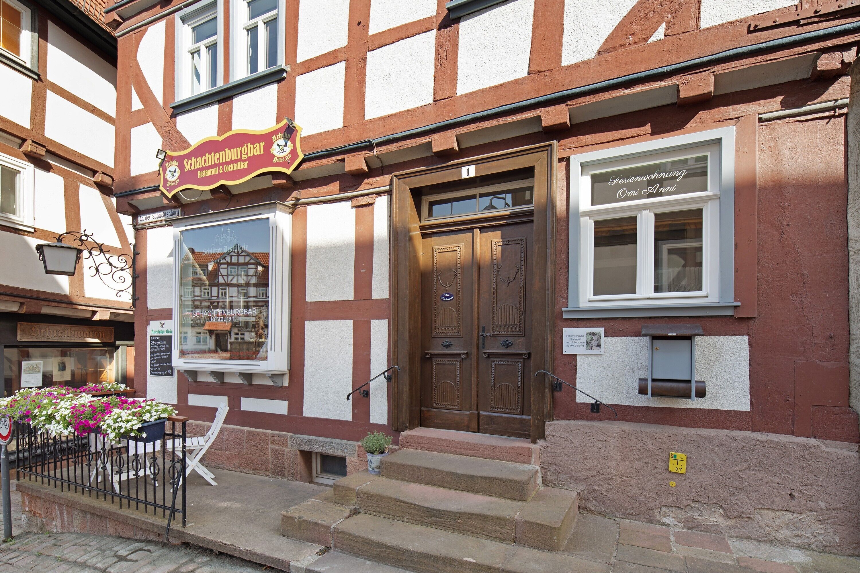 Ein traditionelles Fachwerkhäuschen mit einem Schild für 'Schachtenburghar' und einem Fenster mit einem Schild für 'Omi & Anni'.