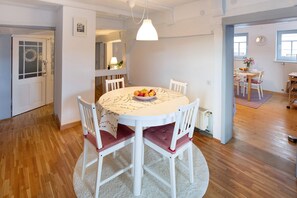 A dining area with a round table, white chairs, and a fruit bowl. - Apartment 'Omi Anni' with a view of the market square, Private Terrace and Wi-Fi (Schlitz)
