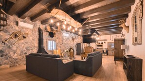 A rustic interior with stone walls, wooden beams, a fireplace, and a cozy seating area. - Constelation Cabin / for big groups, 18 people (La Ciénega de González)
