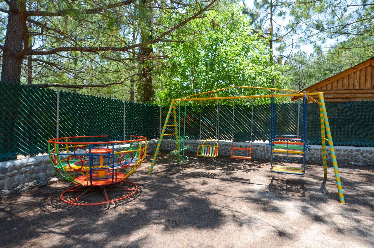 A playground with swings and a climbing structure.