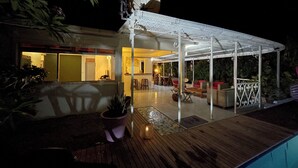 A covered outdoor area with a pool, seating, and a satellite dish.