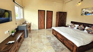 Un dormitorio con una cama grande, un armario de madera y un escritorio con una silla.