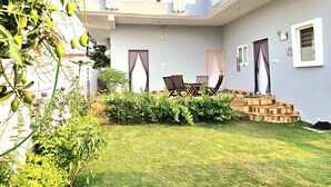 Un patio con zona de comedor, una escalera y vistas del jardín circundante.