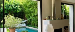 Un interior modern amb vista a la piscina, una llar de foc i un gran finestral.