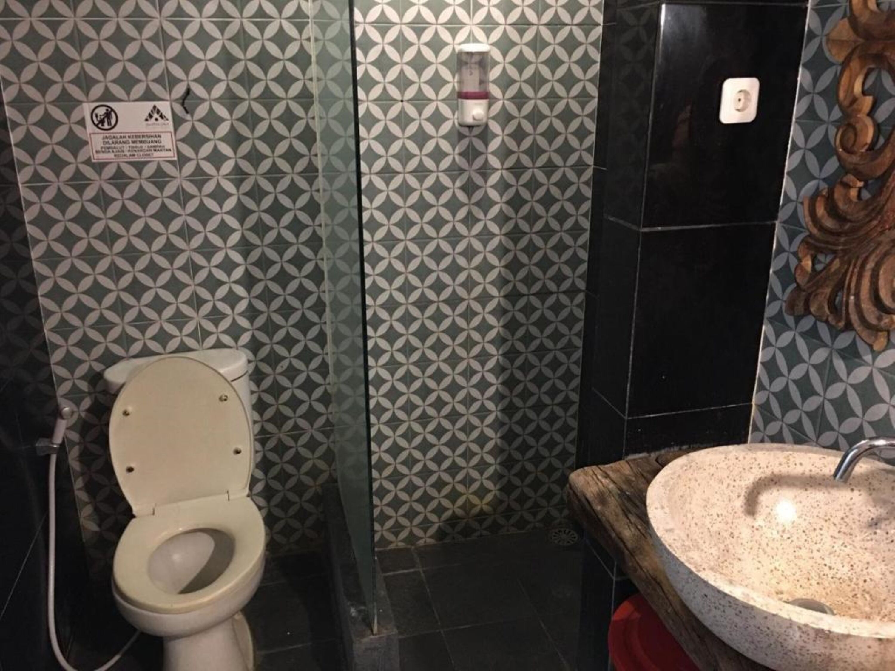 Un bagno con un water, un asciugamani ad aria e un lavandino.