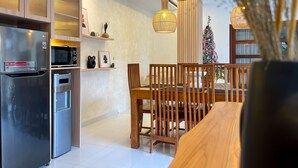 Eine moderne Küche mit Edelstahlgeräten, Holzschränken und einem Essbereich mit Holztisch und Stühlen.