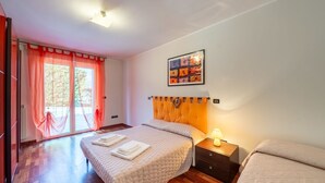 A hotel room with a bed, a nightstand, a window with curtains, and a painting on the wall. - Il Rifugio by Interhome (Città Sant'Angelo)