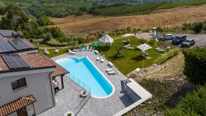A pool area with lounge chairs, a small garden, and a view of the surrounding countryside. - Il Rifugio by Interhome (Città Sant'Angelo)