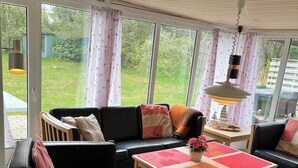 En hyggelig stue med sofa, træbord og bænk.