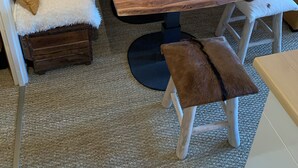 A cozy wooden room with a table, bench, and cushioned seating.