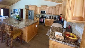 A spacious kitchen with wooden cabinets, granite countertops, and a large island. - Beautiful Log Style Home in Eagle Mountain Estates, Big Bear Lake.  (Big Bear Lake)