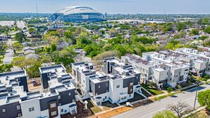 A residential area with modern apartment buildings, a stadium, and a road. - Luxury Stay | Short Walk to AT&T Stadium + Parking (Arlington)